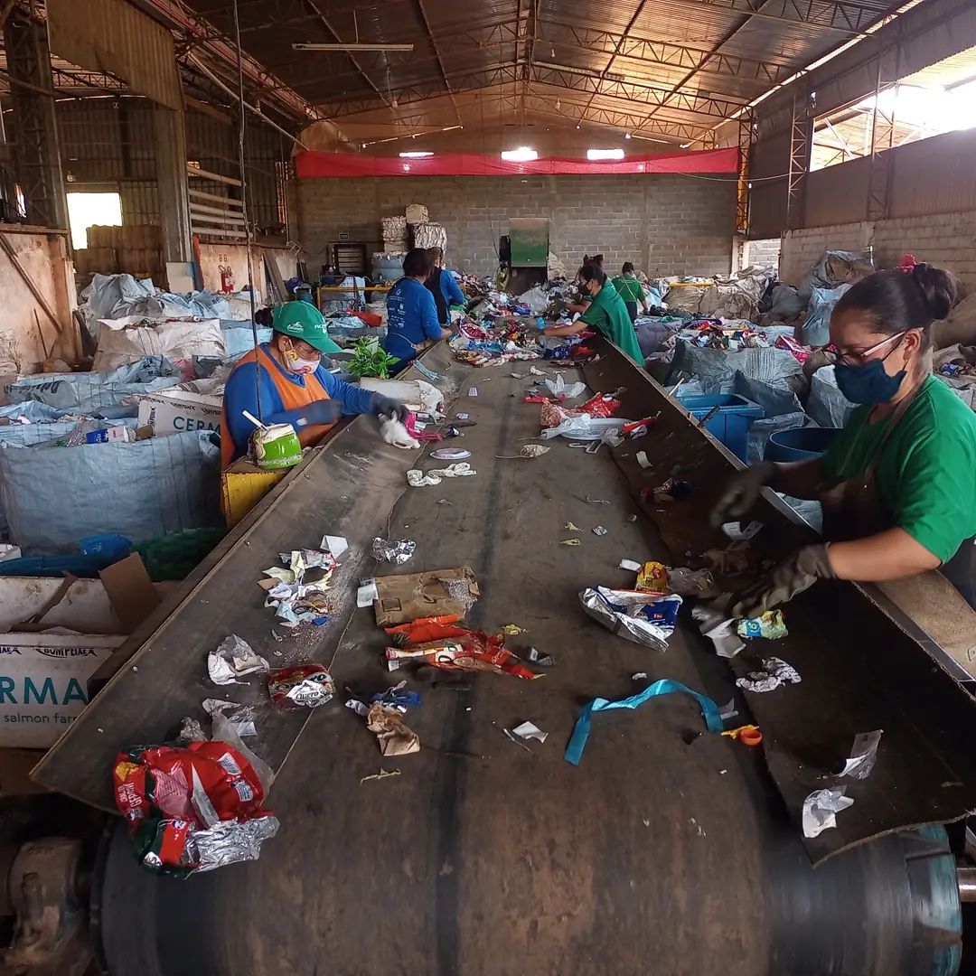 Mãos de cooperados separando materiais recicláveis